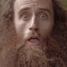 a close up of a man with a beard making a funny face .