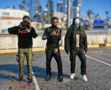 three men standing in a parking lot with one wearing a sweatshirt that says fear on it