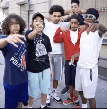 a group of young men are posing for a picture and one of them has a polo shirt on