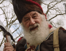 a man with a beard is holding a sword and wearing a fur hat