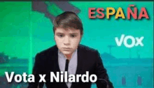 a young man in a suit and tie is standing in front of a screen that says vota x nilardo