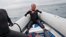 a man in a wet suit is sitting in a boat