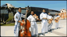 a group of men are playing musical instruments in front of a building that says ' alianza ' on it