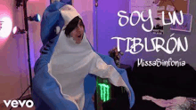 a man in a shark costume is standing in a room .