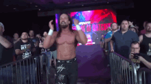 a wrestler is standing in front of a crowd with a sign that says ' i 'm a winner '