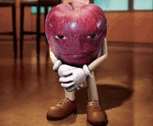 a cartoon apple with arms and legs is sitting on the floor with his hands on his knees .