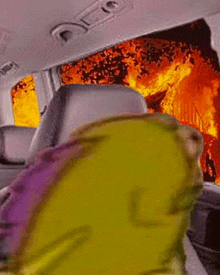 a cartoon character is sitting in the back seat of a car with a fire in the background .