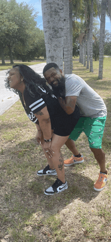 a man is carrying a woman on his back while wearing nike shoes