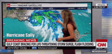 a cnn newsroom screen shows a weather report on hurricane sally