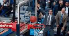 a man in a suit and tie is watching a basketball go through a hoop with a state farm sign in the background