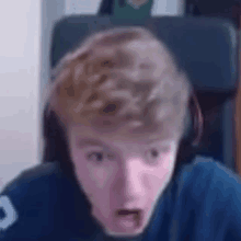 a young man wearing headphones is making a surprised face .