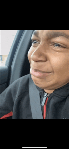 a close up of a person making a funny face while sitting in a car