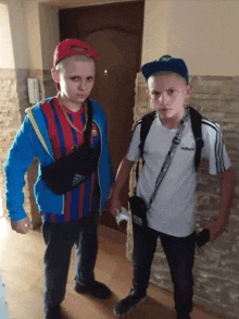 two boys standing next to each other with one wearing a white adidas shirt