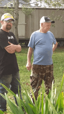 two men standing next to each other one wearing a hat that says tigers