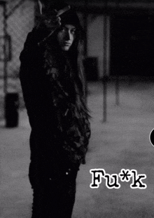 a black and white photo of a woman giving the middle finger with the word fuck written below her