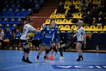 a handball game is being played in a stadium and one of the players is wearing the number 6