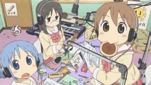 a group of three anime girls are sitting in front of a microphone in a room .