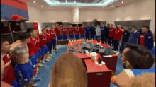 a group of soccer players in a locker room with one wearing a shirt that says ' fc barcelona ' on it