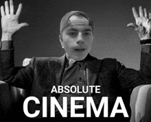 a black and white photo of a man with his hands in the air and the words absolute cinema below him