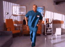 a man in scrubs is dancing in a hospital