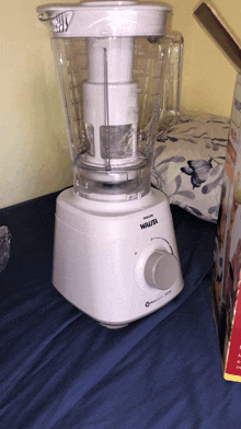 a white walita blender sits on a bed next to its box