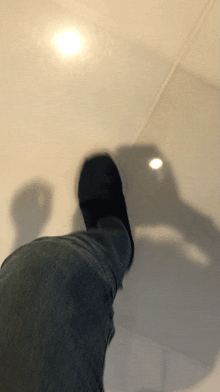 a shadow of a person 's foot is cast on the floor