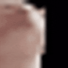 a blurred image of a person 's face with a black background