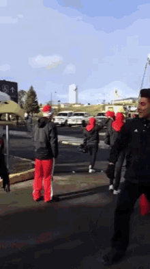 a group of people wearing santa hats are walking down a street in front of a sign that says ' a ' on it