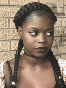 a woman wearing a choker and hoop earrings looks to the side