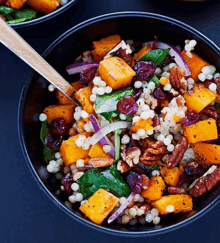 a bowl of food with a wooden spoon in it on a table