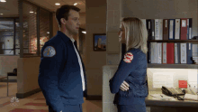 a man and a woman are standing next to each other and the man 's jacket has a patch that says chicago fire department