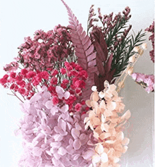 a bouquet of pink and purple flowers in a vase on a table .