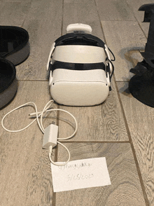 a white oculus headset is sitting on a tiled floor next to a note that says u/faggyjmkgu