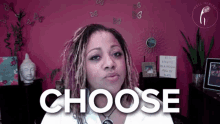 a woman with dreadlocks is standing in front of a pink wall and the word choose is on the screen