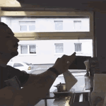 a man sitting at a table in front of a window with a sign that says ' fried chicken ' on it