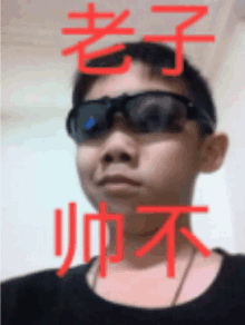 a man wearing sunglasses and a black shirt with chinese writing behind him