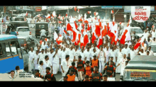 a large group of people marching down a street with a sign in the background that says ' kerala '