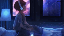 a boy wearing headphones is sitting on a bed looking out a window .