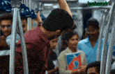 a man in a red shirt is holding onto a railing on a train with a sign that says " lamhemuk "