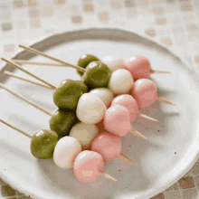 green white and pink balls on sticks on a plate