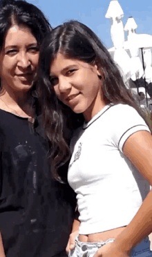 a woman and a girl are posing for a picture together