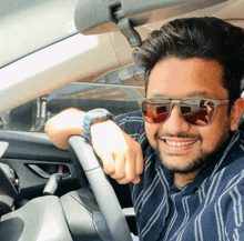 a man wearing sunglasses leans on the steering wheel of his car