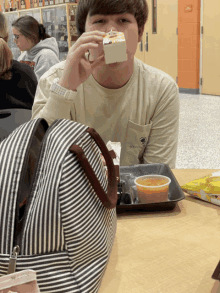 a boy sitting at a table eating a cupcake with a shirt that says liberty on it