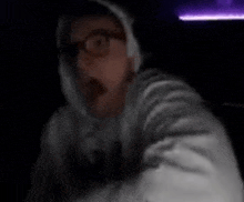 a blurry picture of a person wearing a hoodie and glasses