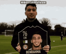 a man holding up a picture of benrahma with the number 76 on it