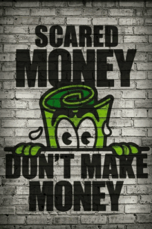 a poster on a brick wall says scared money don 't make money