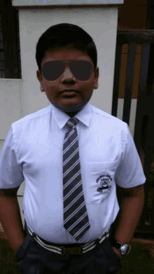 a boy wearing sunglasses and a white shirt with a badge that says ' swami vivekananda '