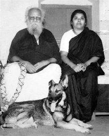 a black and white photo of a man and a woman sitting next to a dog