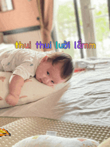 a baby is laying on a pillow with the words thui thui luoi lamm written on the top