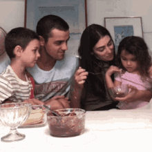 a family sits at a table with a bowl of food in front of them and a poster that says ' mexico ' on it